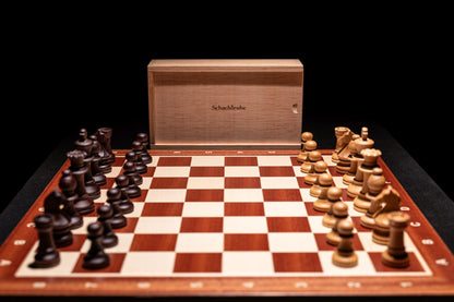 Aufgebautes Schachspiel Baltaraz in matt mit Aufbewahrungstruhe im Hintergrund