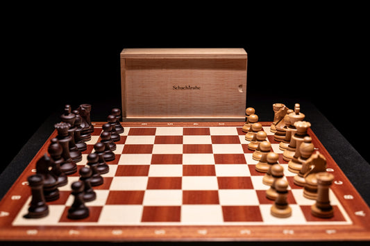 Aufgebautes Schachspiel Baltaraz in matt mit Aufbewahrungstruhe im Hintergrund