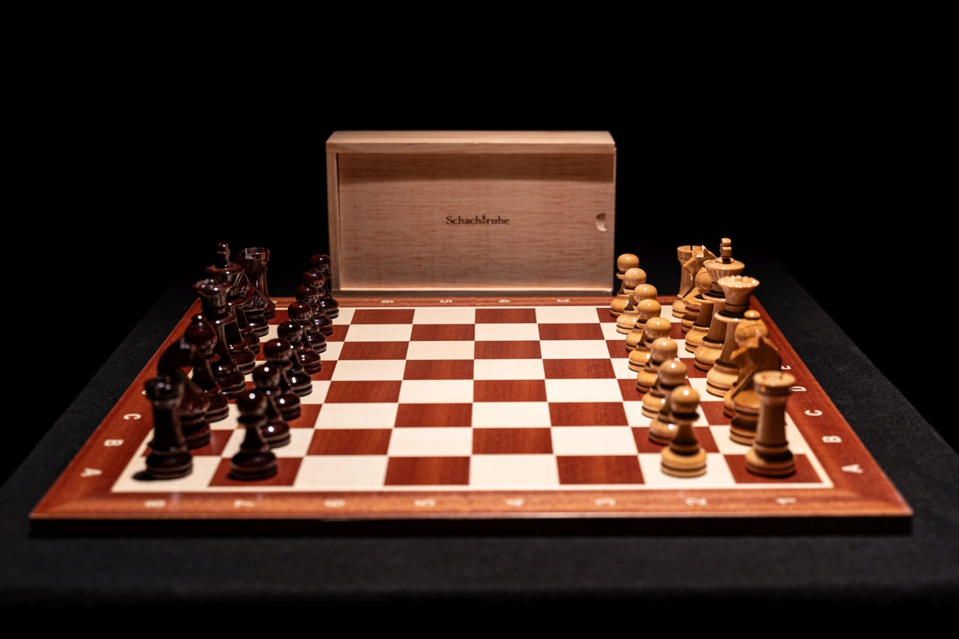 Aufgebautes Schachspiel Baltaraz in glänzend mit Aufbewahrungstruhe im Hintergrund