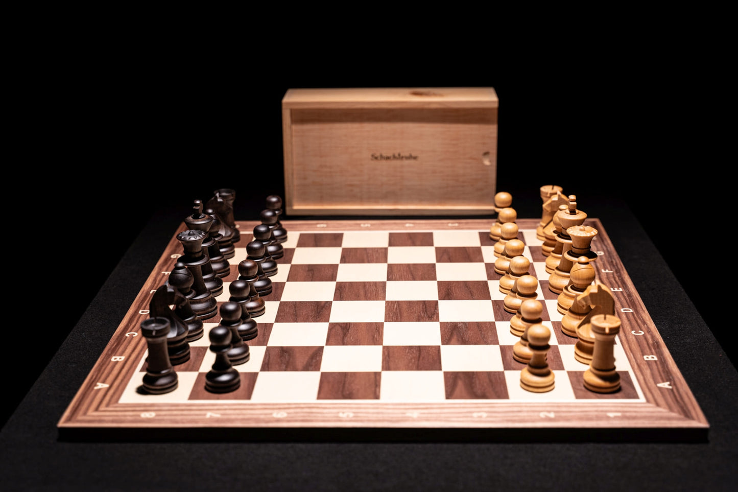 Aufgebautes Schachspiel Marisapo in matt mit Aufbewahrungstruhe im Hintergrund