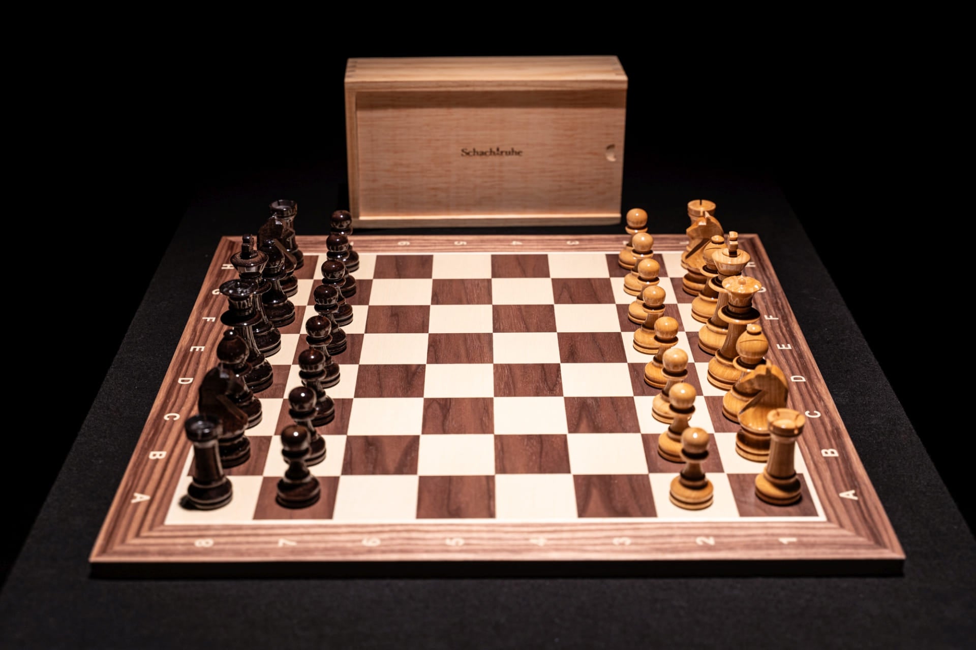 Aufgebautes Schachspiel Marisapo in glänzend mit Aufbewahrungstruhe im Hintergrund