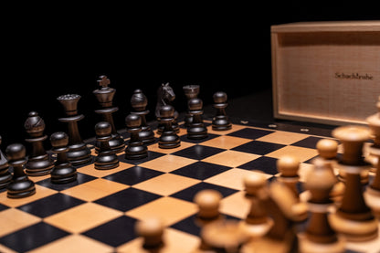 Aufgebaute schwarze Figuren des Schachspiels Zilata in matt