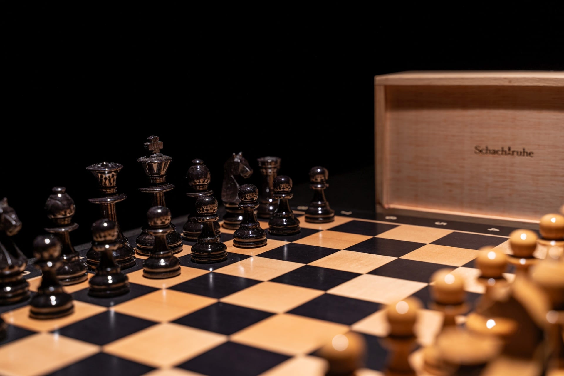 Aufgebaute schwarze Figuren des Schachspiels Zilata in glänzend