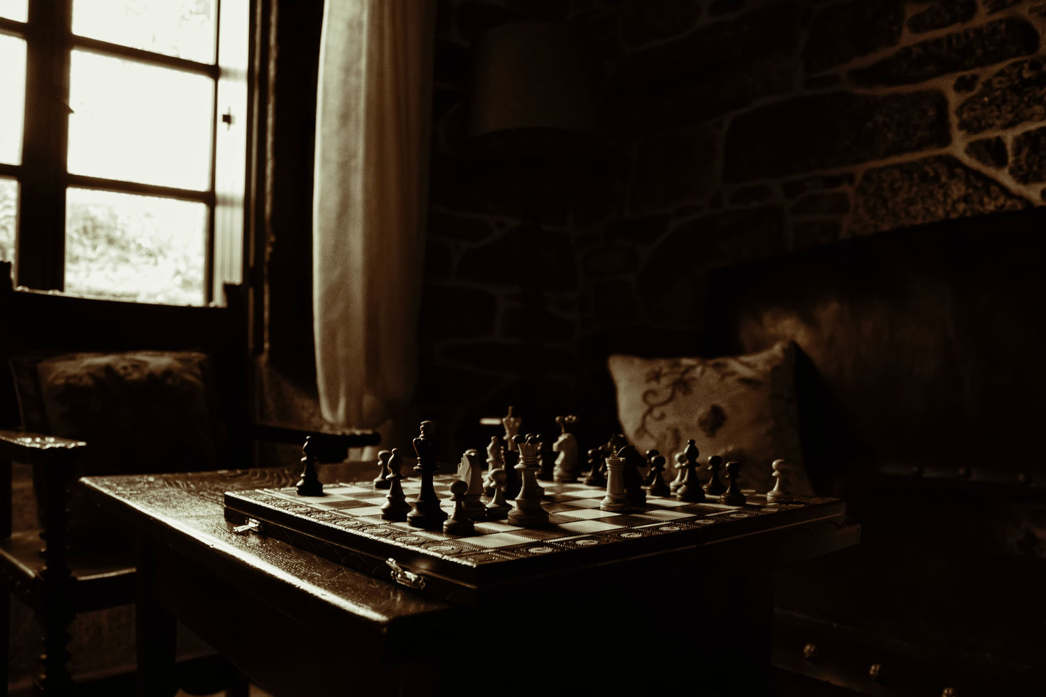 Schachkassette und -figuren auf Holztisch ingGemütlichem Wohnzimmer mit Ledersessel