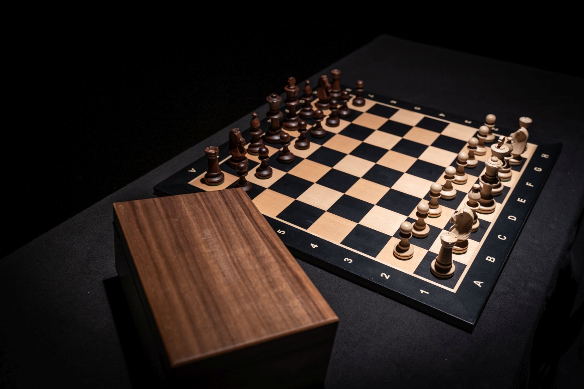 Aufgebautes Schachspiel Calinea mit Aufbewahrungstruhe im Vordergrund