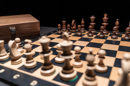 Aufgebautes Schachspiel Calinea mit Aufbewahrungstruhe im Hintergrund
